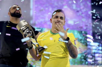 PHzin sinaliza em alusão aos cinco títulos mundiais do Brasil no futebol, enquanto segura troféu da Copa do Mundo de FIFA 22 — Foto: Joe Brady / Fifa / Getty Images