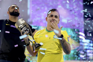 PHzin sinaliza em alusão aos cinco títulos mundiais do Brasil no futebol, enquanto segura troféu da Copa do Mundo de FIFA 22 — Foto: Joe Brady / Fifa / Getty Images