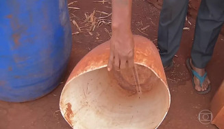 Indígena da reserva urbana de Dourados mostra balde de água vazio — Foto: Reprodução/TV Morena
